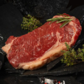 Ein rohes Rumpsteak vor dunklem Hintergrund